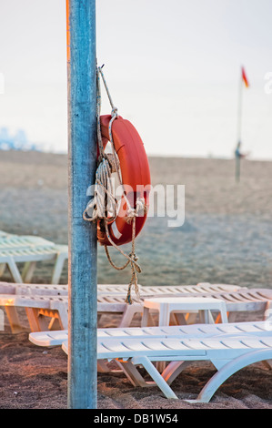 Bouée accroché sur un poteau sur la plage publique. Banque D'Images