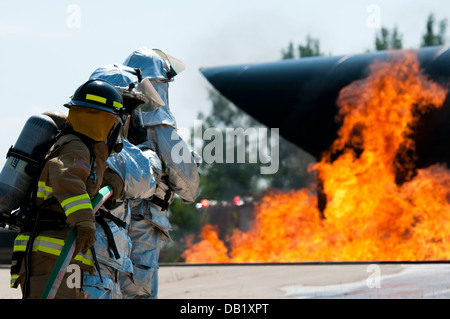 Une réserve de l'armée américaine, pompier, gauche et deux gardes nationaux Air Mississippi travaux d'éteindre un incendie à Volk Field la préparation au combat au Centre à Camp Douglas, Wisconsin, le 18 juillet 2013, lors de l'exercice Patriot 13. L'exercice est un patriote op domestiques Banque D'Images