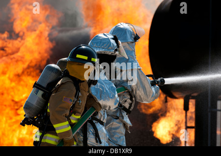 Une réserve de l'armée américaine, pompier, gauche et deux gardes nationaux Air Mississippi travaux d'éteindre un incendie à Volk Field la préparation au combat au Centre à Camp Douglas, Wisconsin, le 18 juillet 2013, lors de l'exercice Patriot 13. L'exercice est un patriote op domestiques Banque D'Images