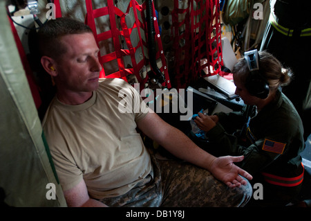 Le sergent de l'armée américaine. Michael Monroe, gauche, avec la 112e Détachement des affaires Public Mobile, la Garde nationale du Wisconsin, se prépare à recevoir un IV de l'Armée de l'air hauts Airman Karissa brun, avec le 109e Escadron d'évacuation aéromédicale, Illinois N'Air Banque D'Images