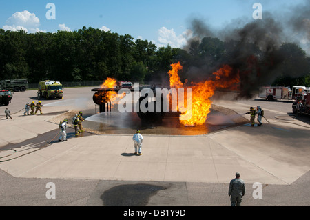 Des équipes de la Garde nationale aérienne de l'armée américaine et réserver les pompiers travaillent d'éteindre un incendie à Volk Field la préparation au combat au Centre à Camp Douglas, Wisconsin, le 18 juillet 2013, lors de l'exercice Patriot 13. La Patriot l'exercice est un scénario d'opérations nationales t Banque D'Images