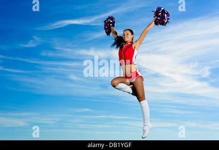 Les jeunes en cheerleader costume rouge jumping Banque D'Images