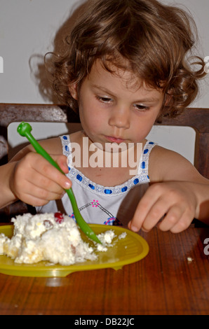 Petite fille 4 ans de manger un gâteau Banque D'Images