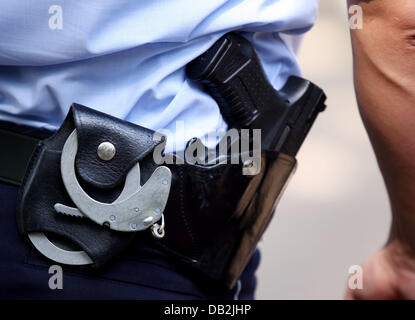 Fichier - une archive photo datée du 28 juin 2011 montre un policier à l'usage de menottes et canon est vu à Cologne, Allemagne. Selon une stastitc de la conférence des ministres de l'Intérieur, des agents de police ont tué huit personnes par leurs coups de pistolet et ont blessé 23. Photo : Oliver Berg Banque D'Images