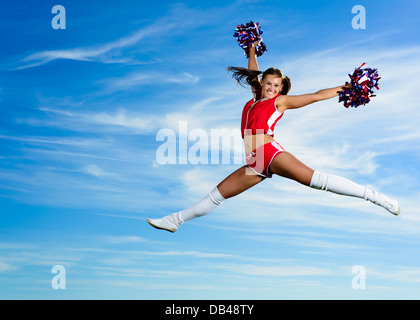 Les jeunes en cheerleader costume rouge jumping Banque D'Images