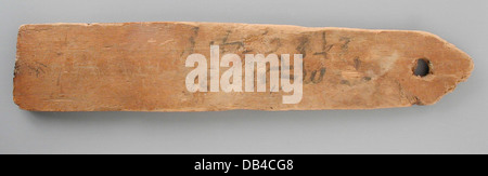 Cette étiquette de momie est inscrite avec un texte bilingue, offrant un aperçu des pratiques funéraires égyptiennes anciennes et de l'identité de l'individu. Il présente des inscriptions en hiéroglyphes et dans une autre langue, fournissant un contexte archéologique et historique précieux. Banque D'Images