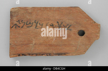 Cette ancienne étiquette de momie égyptienne comporte une inscription bilingue, probablement utilisée pour identifier ou étiqueter un individu momifié. Il représente le système complexe d'écriture et de documentation utilisé dans les pratiques funéraires. Banque D'Images