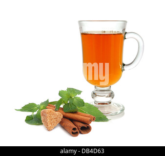 Thé, feuilles de menthe, sucre de canne en forme de cœur et des bâtons de cannelle sur fond blanc Banque D'Images