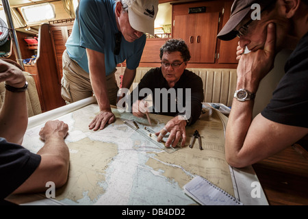 Le capitaine et l'équipage étudient les cartes de navigation pour déterminer le parcours de navigation Banque D'Images