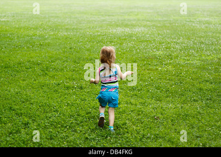 Le jeune enfant qui traverse une prairie Banque D'Images