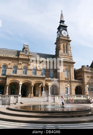 Jeune garçon cools off en fontaine en face de l'hôtel de ville de Southport en été, canicule, North West England, UK Banque D'Images