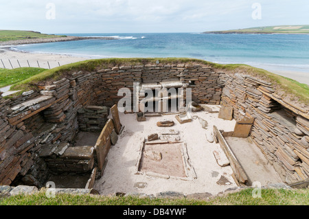 1 chambre à Skara Brae village néolithique des Orcades sur le continent avec la baie de Skaill en arrière-plan. Banque D'Images