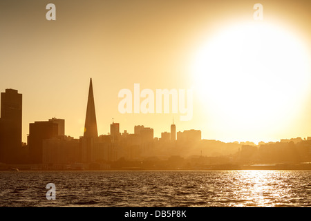 Grand, lumineux blanc soleil brille sur San Francisco silhouetting l'horizon au coucher du soleil. Banque D'Images Grand, lumineux blanc soleil brille sur San Francisco silhouetting l'horizon au coucher du soleil. Banque D'Images