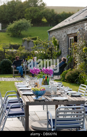 Des repas en plein air dans le jardin d'une grange convertie dans le Devon UK Banque D'Images