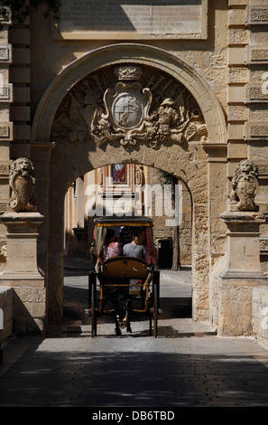 Transport de chevaux en passant par le portail principal de l'ancienne citadelle de Mdina dans l'île de Malte Banque D'Images