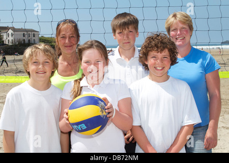 Sur la plage de Polzeath au soleil St Merryn jeunes et leur entraîneur, attendent avec impatience le jeu d'allumette Banque D'Images