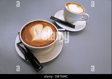 Une grande tasse et une petite tasse de Cappuccino avec un cœur dans la mousse de lait Banque D'Images