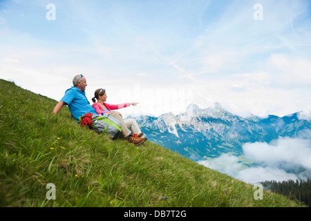 Les randonneurs assis sur une prairie de montagne et profiter de la vue de la montagnes de Tannheim Banque D'Images