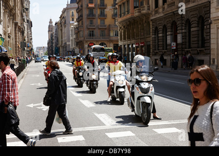 Les personnes qui traversent la route en face de l'attente des scooters sur la Via Laietana, dans la vieille ville de Barcelone Catalogne Espagne Banque D'Images