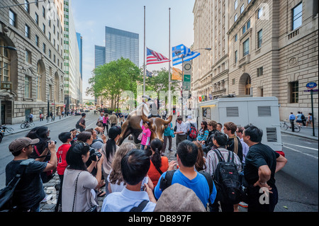 Une foule de gens posent et prendre des photographies au Wall Street Bull charge dans NYC Banque D'Images