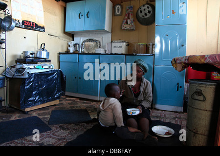 L'alimentation de la mère à son enfant dans une baraque à Kliptown township de Soweto, Johannesburg Banque D'Images