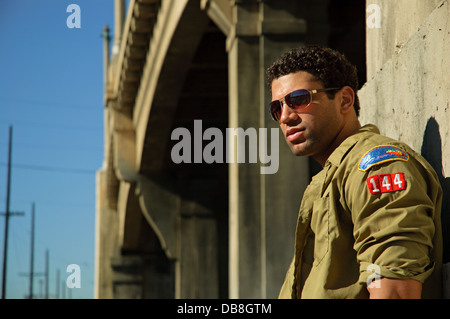 African American fashion modèle masculin portant des lunettes de soleil qui pose en dessous d'un pont dans le centre-ville de los angeles Banque D'Images