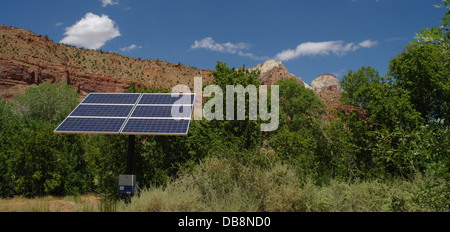 Ciel bleu voir panneau solaire l'augmentation des arbres verts de la vallée au-dessous des falaises de grès brun, Visitor Centre, Zion Canyon, Utah, USA Banque D'Images