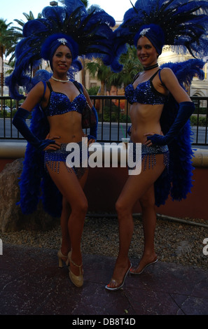 Deux showgirls, souriant les bras sur les hanches, bleu plumes, robes de tête, du trottoir, pose, près de Harrah's Sign, Las Vegas Strip Banque D'Images