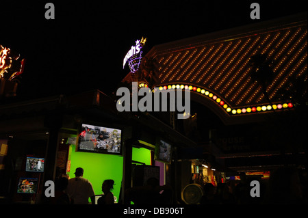 Vue de nuit, à façade néon Harrah's Casino, les gens se tenant devant un écran vert, 'célèbre Vegas Bike Ride', Bande de Las Vegas, USA Banque D'Images