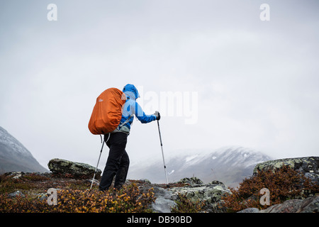 Female hiker en cas de tempête dans le sud de fin de Tjäktjavagge sur Kungsleden trail, Laponie, Suède Banque D'Images