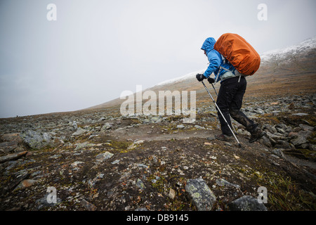 Female hiker randonnées sur terrain rocailleux dans Tjäktjavagge sur Kungsleden trail, Laponie, Suède Banque D'Images