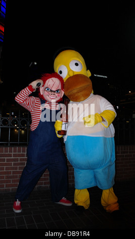 Portrait de nuit deux animateurs déguisés en Chucky Jeu d'enfant poupée et Homer Simpson, trottoir, Bill's Casino, Las Vegas Strip Banque D'Images