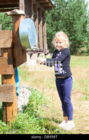 Smiling Blonde hair Girl standing avec lavabo en été, piscine Banque D'Images