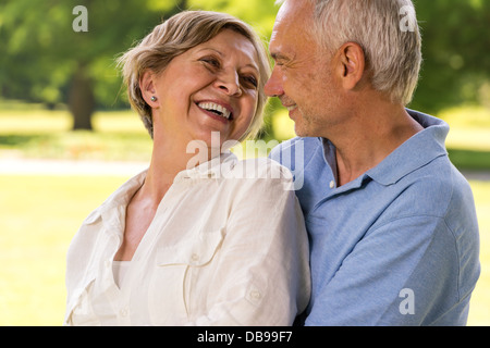 Bonne retraite senior couple hugging and smiling at each other Banque D'Images
