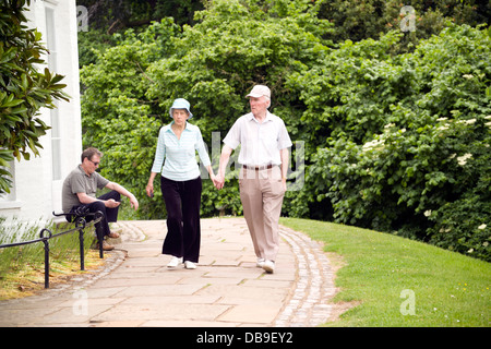 Diverses personnes âgées adultes matures walking in park homme adultes femmes adultes et fauteuil Banque D'Images