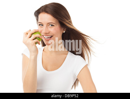 Les jeunes et gaies woman eating a green apple, isolated on white Banque D'Images