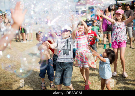 Malmesbury, Wiltshire, Royaume-Uni. 26 juillet 2013. Chase enfants bulles au festival WOMAD dans Charlton Park près de Malmesbury dans le Wiltshire. La world music festival attire près de 40 000 personnes à la zone rurale. 26 Juillet 2013 Crédit : Adam Gasson/Alamy Live News Banque D'Images