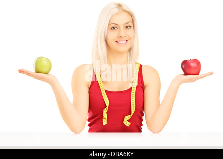 Female tenant deux pommes et un ruban à mesurer autour de son Banque D'Images