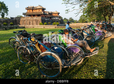 Un groupe de cyclo non identifiés chauffeurs attendent les touristes en face de la Citadelle Le 10 janvier 2008 à Hue, Vietnam Banque D'Images