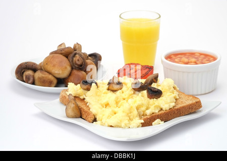 Des œufs brouillés sur du pain grillé avec des haricots blancs, les champignons et le jus d'orange Banque D'Images