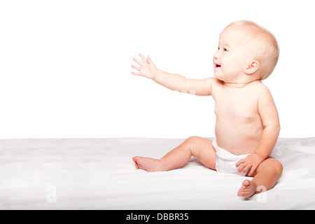 Adorable bébé enfant mignon s'adressant avec la part de demander quelque chose en étant assis, sur blanc. Banque D'Images