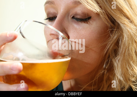 Jeune fille blonde boire une bière Banque D'Images