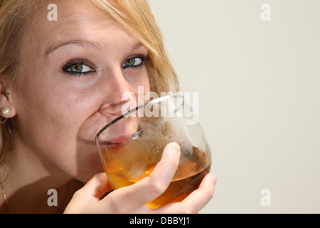 Jeune fille blonde boire une bière Banque D'Images