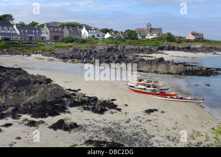 Le littoral d'Iona du quai des ferries à travers St Ronans Bay avec une vue sur les maisons et l'abbaye avec des kayaks sur la plage. Banque D'Images