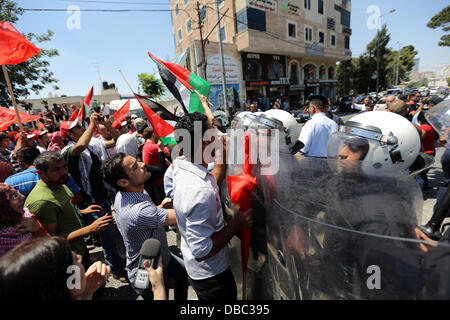 Ramallah, Cisjordanie, territoire palestinien. 28 juillet, 2013. La police anti-émeutes palestiniennes en conflit avec les manifestants contre les prochaines négociations entre les dirigeants palestiniens et Israël, ils essaient d'une marche vers le siège du président palestinien Mahmoud Abbas, dans la ville de Ramallah, en Cisjordanie le 28 juillet 2013. Le Premier ministre israélien Benjamin Netanyahu était à la recherche de l'approbation du cabinet pour une sortie de 104 contentieux palestinien et ancien combattant prisonniers israélo-arabe, pour coïncider avec la reprise des pourparlers de paix qui ont été bloquées depuis septembre 2010 (Crédit Image : © Issam Rimaw Banque D'Images