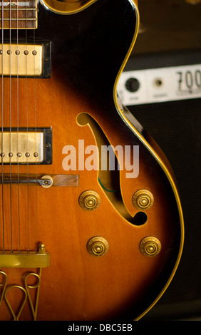 Corps d'une guitare jazz semi-acoustique. Skeedio Ibanez. Avec un petit amplificateur derrière elle. Banque D'Images