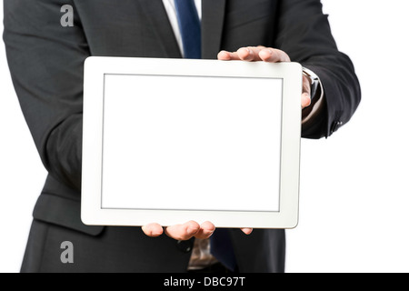 L'homme d'affaires en costume sombre est titulaire d'un ordinateur tablette, isolé sur fond blanc Banque D'Images