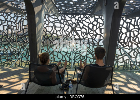 Marseille France, Architecture moderne , couple détente dans les chaises, Bâtiment du Musée MUCEM, "la musée des civilisations de l'Europe et de la Méditerranée", Sud de la France , toit café (Credit Architect: 'Rudy Riciotti') investissement dans la construction durable, architecture contemporaine, design urbain france Banque D'Images