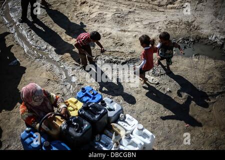 28 juillet 2013 - Khany Yunis, la bande de Gaza, territoire palestinien - une femme palestinienne remplit bottels avec de l'eau d'un robinet public à Khan Younis dans le sud de la bande de Gaza, le 28 juillet 2013 (Crédit Image : © Mahmoud Hamda/APA Images/ZUMAPRESS.com) Banque D'Images