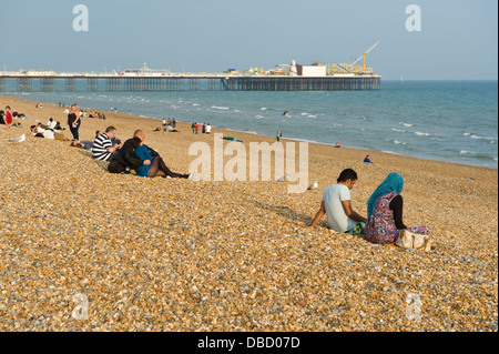 Les vacanciers se détendre dans le soleil d'été sur la plage de Brighton East Sussex England UK Banque D'Images